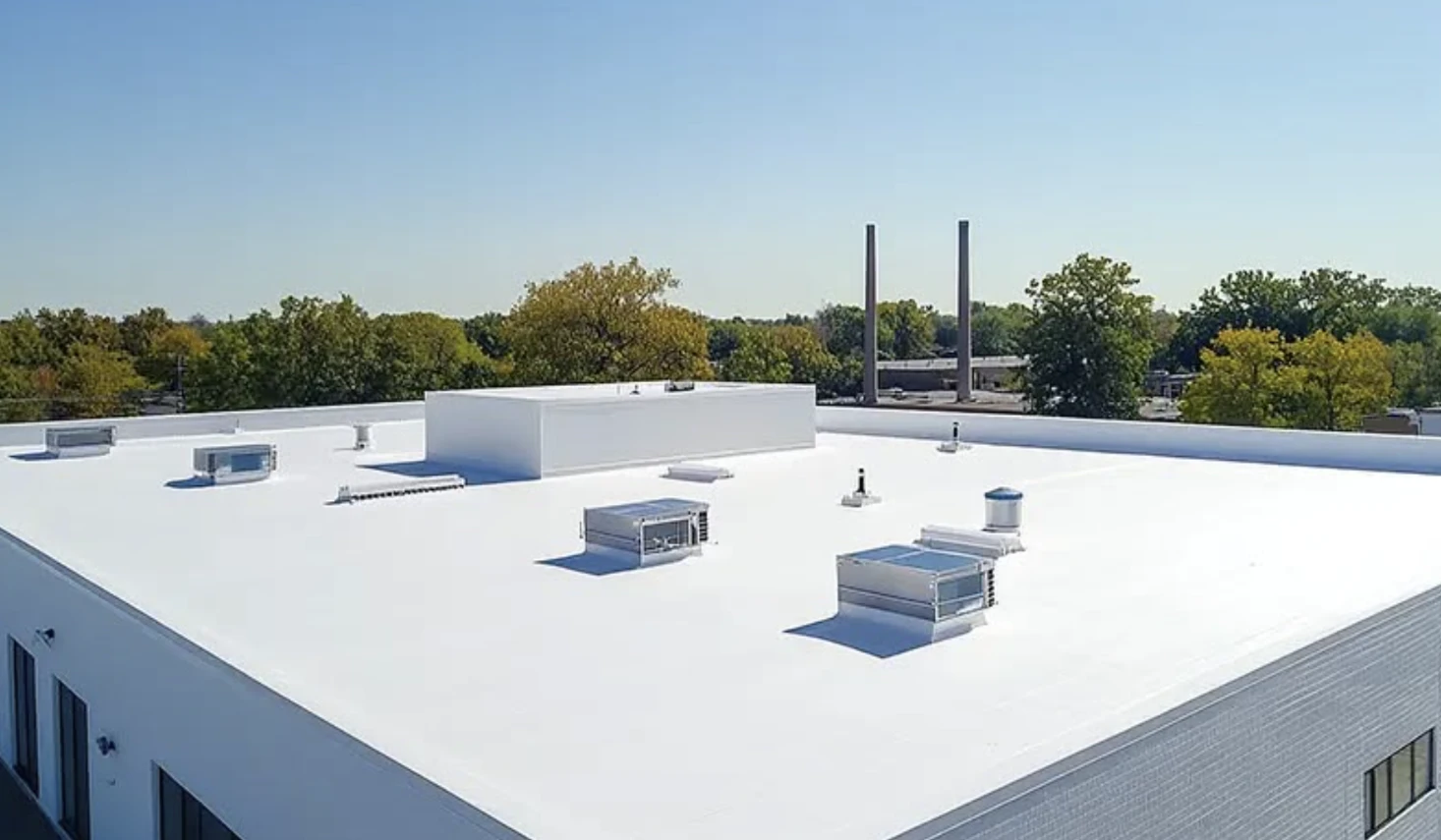 Completed commercial flat roof in Bismarck, North Dakota, featuring white membrane roofing, HVAC units, and vents by Bismarck Exterior Pros.
