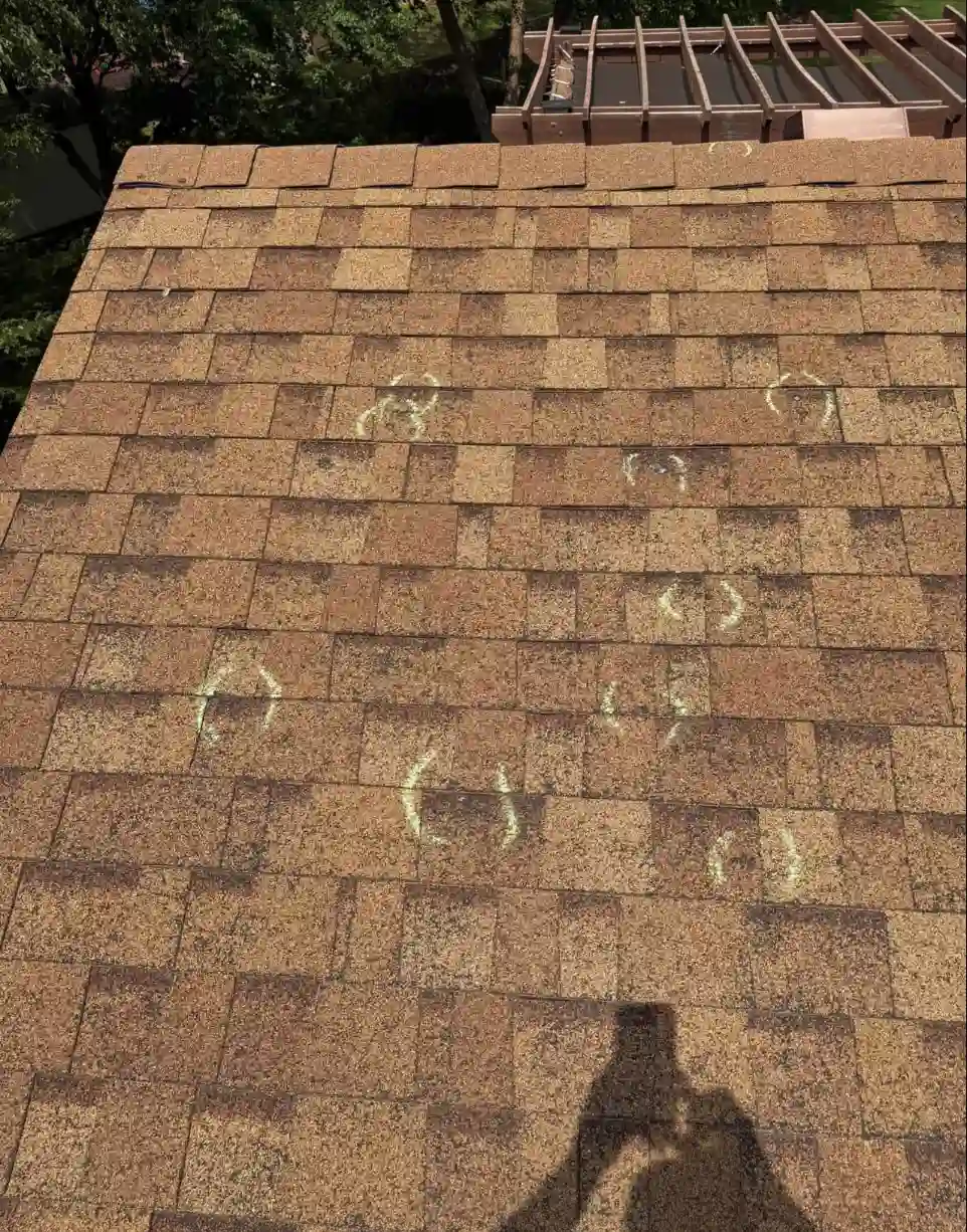 Bismarck, North Dakota roof inspection showing hail damage marked with chalk circles on asphalt shingles by Bismarck Exterior Pros.