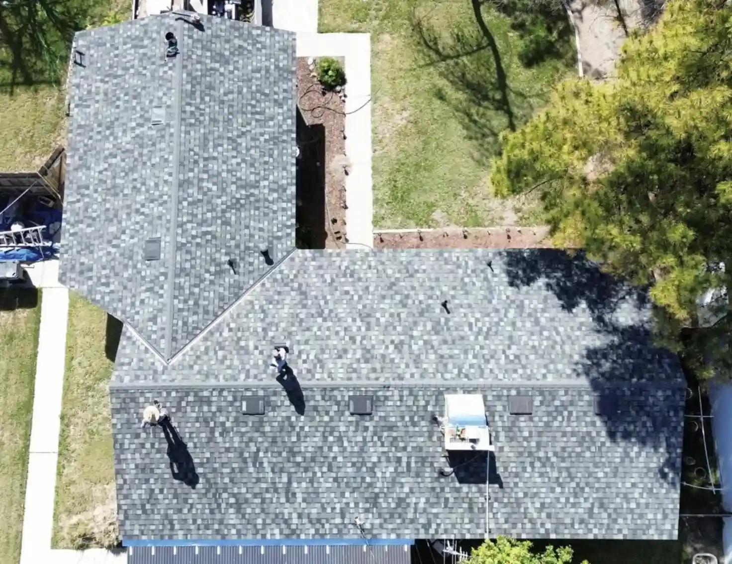Aerial view of Bismarck, North Dakota roofers installing new asphalt shingles on a residential roof by Bismarck Exterior Pros.