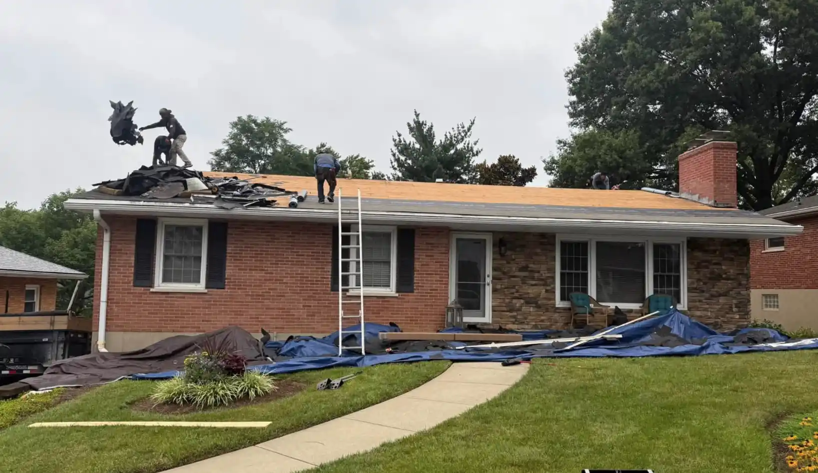 Storm damage roof restoration in Bismarck, North Dakota, showing tear-off of damaged shingles and exposed decking by Bismarck Exterior Pros.